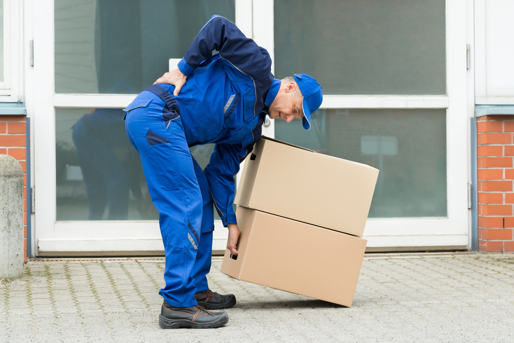 A person with back problems lifting boxes