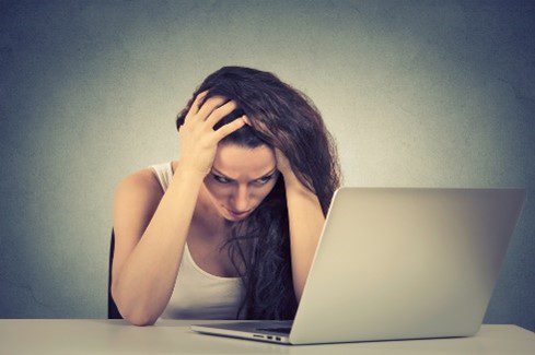 A woman with stress looking at the laptop