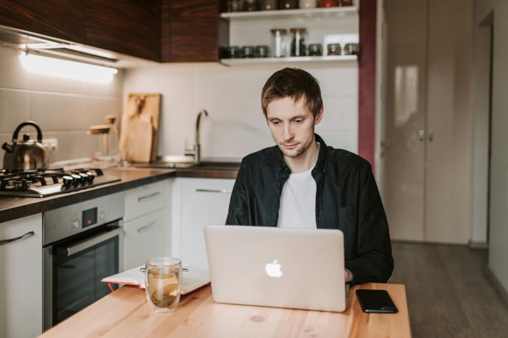 young man working from kitchen table work from home office