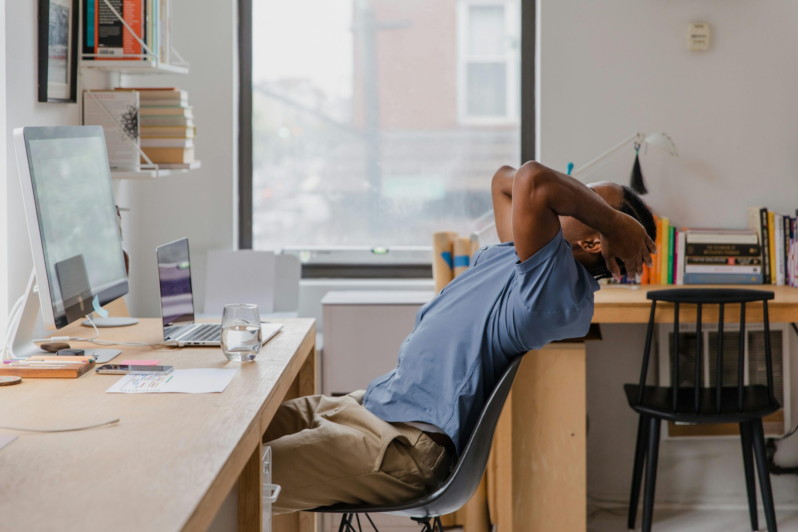 young man leaning back from desk in home office chair