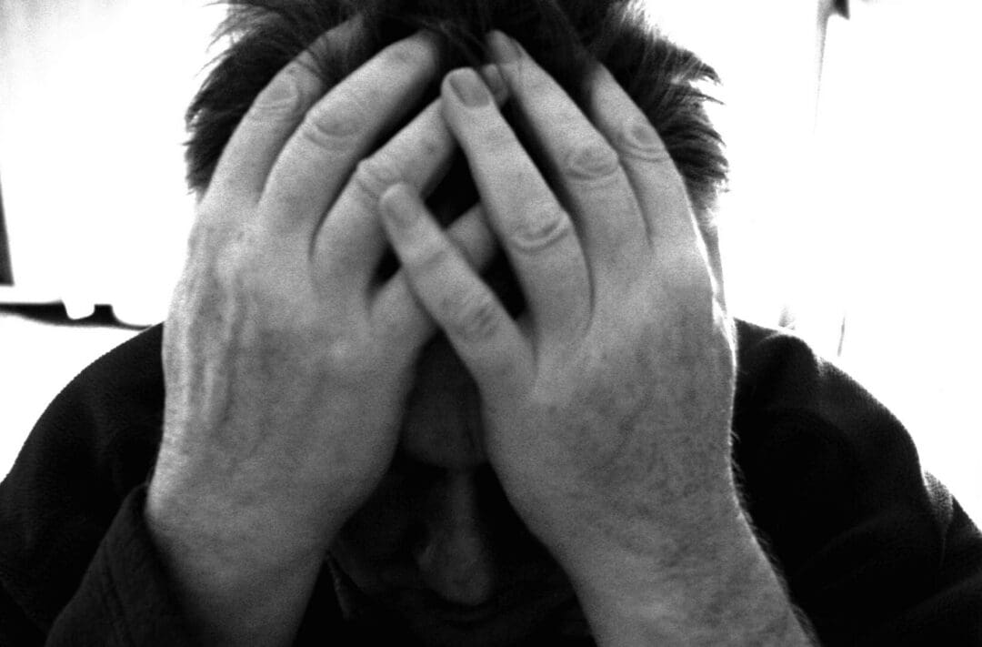 Person holding head in hands, looking distressed.