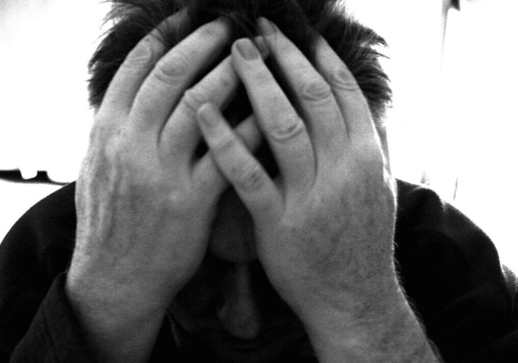 Person holding head in hands, looking distressed.