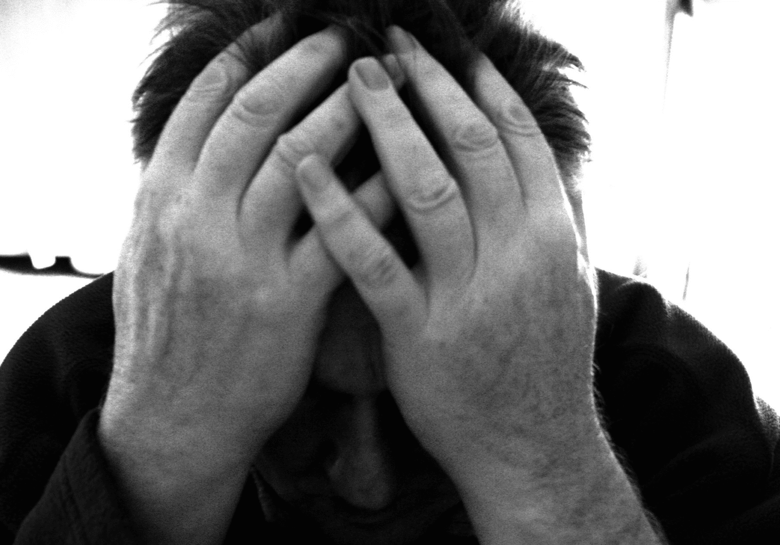 Person holding head in hands, looking distressed.