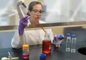 lab worker using pipette with vent hood 1