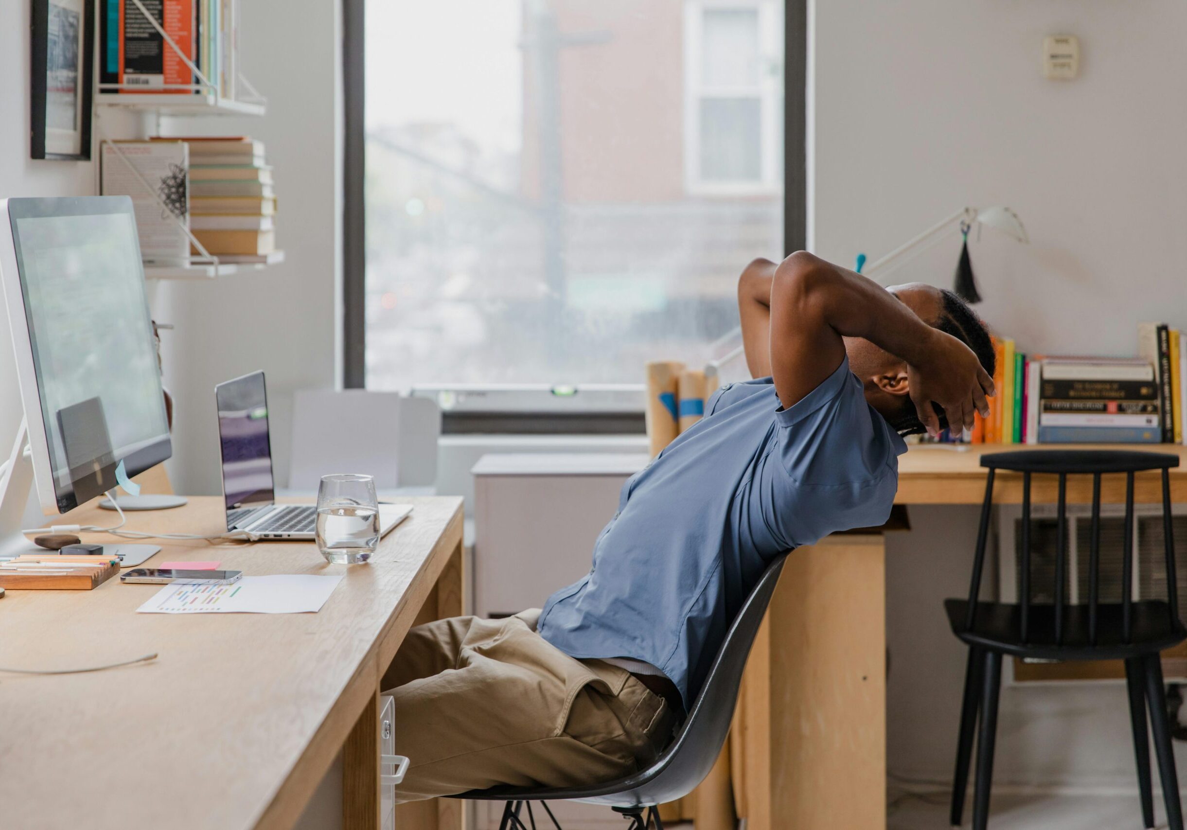 young man leaning back from desk in home office chair